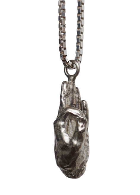 side-profile of a silver hand pendant hanging from a silver chain
