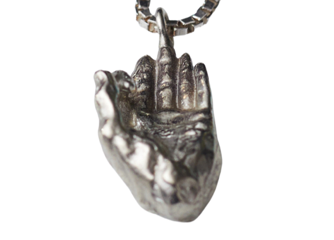 close detail of the palm of the silver pendant hand